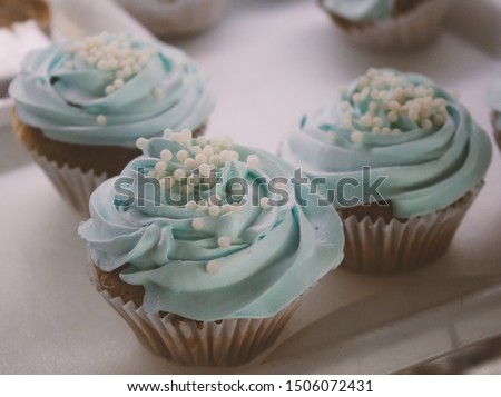 Turquoise cupcake in bakery, beautiful handmade decoration with pearls and blue butter cream. Delicious little cake, fashion and vintage picture. 