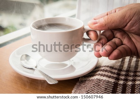 closeup holding hot cup of coffee