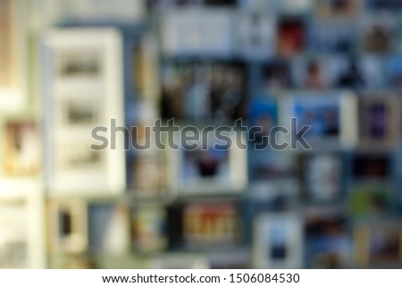 Blurred background with photos in frames put up on a wall. Concept for keeping good memories about holidays or vacation.