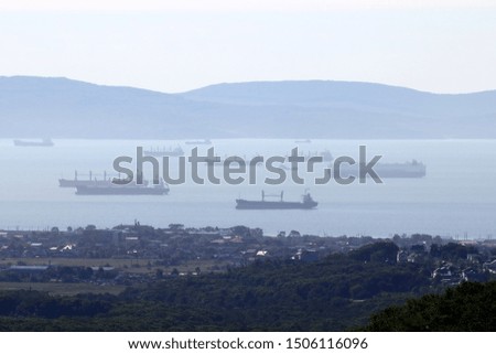Many ships standing at anchor in harbour. General cargo ships, tankers and others. 