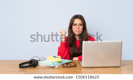 Teenager student girl studying in a table with angry gesture