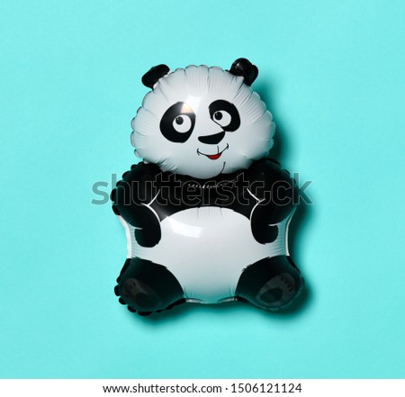 Little panda balloon for present on birthday on light blue green background