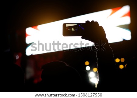 Smartphone silhouette in hands at a music show. Shooting of stage