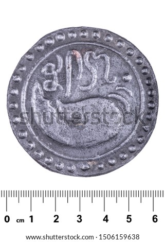 An ancient coin of the kingdom of Funan with a picture of a shell and an inscription in an ancient forgotten language. Obverse. Isolated on white