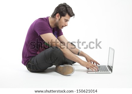 Young male working on a laptop with shocked expression