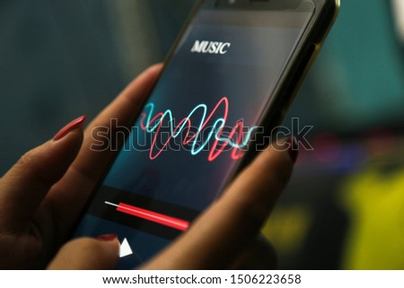 hands showing music application on a smart phone