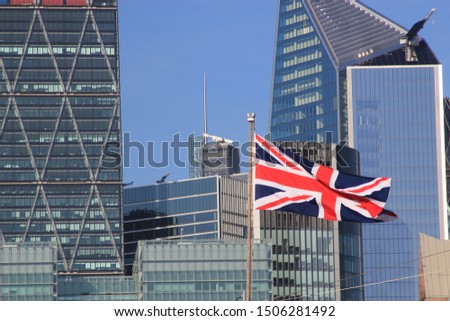 Union Jack flag flying in front of the modern buildings of the City of London designating Brexit and the London financial centre Royalty-Free Stock Photo #1506281492