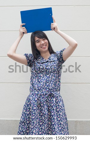 Smiling woman holding blank billboard.