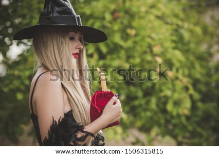 Halloween holiday witch Lady wear black hat and stylish dress in Mystical atmosphere outdoors, celebrate autumn