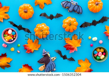 Nice halloween background with sweets. Cookies and pumpkins on blue top view pattern