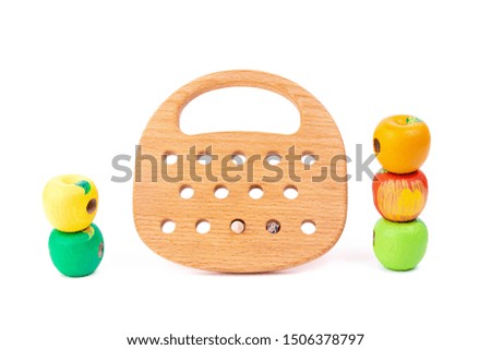 Photo of a wooden wooden toy with beads of different colors on wheels  of beech. Toy made of wood  on a white isolated background.A toy for entertaining children and resting parents