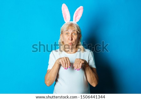 Old woman with rabbit or hare ears on a blue background. Easter concept