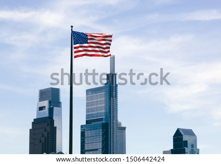 The USA flag overlooking skyscrapers background. Philadelphia downtown