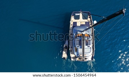 Aerial drone top down photo of luxury Catamaran sailboat anchored in Mediterranean popular Aegean destination port with deep blue sea