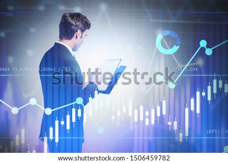 Rear view of handsome young business consultant working with clipboard over blurred background with double exposure of forex graphs. Concept of trading and hi tech. Toned image