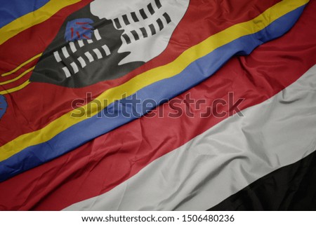 waving colorful flag of yemen and national flag of swaziland. macro