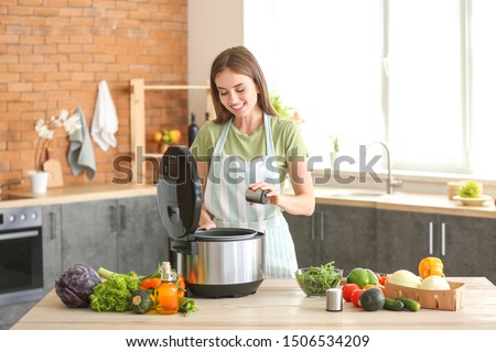 Woman using modern multi cooker in kitchen Royalty-Free Stock Photo #1506534209