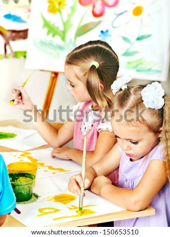 Child painting at easel in school.