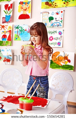 Child girl with clay in play room. Preschool.