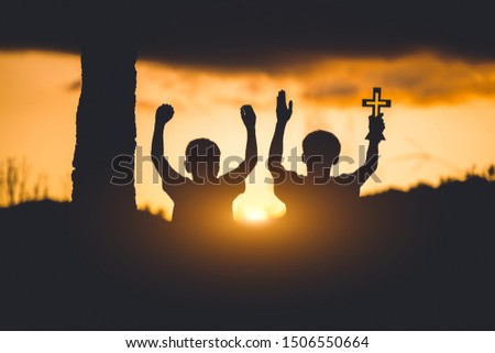 Two young christians worshiping to God ,christian silhouette  concept.