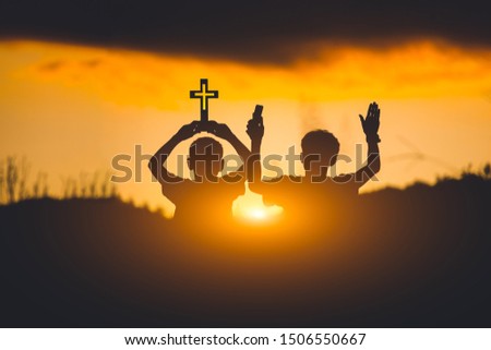 Silhouette of two young christians worshiping God ,christian concept.