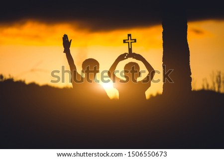 Two young christians worshiping God ,christian silhouette  concept.