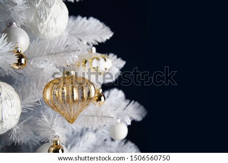 Decorated white and golden ornaments white Christmas tree on dark background. Merry Christmas and Happy Holidays greeting card, frame, banner. New Year. Winter holiday theme. 