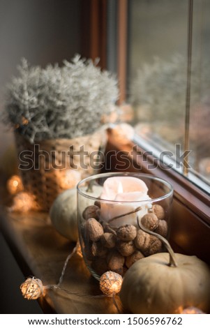autumn cosy candles and pumpkin on window, autumn decoration and led lights, boke, scandinavian style, hugge, still life