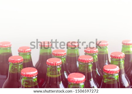 Green glass bottles without labels with dark liquid with metal easy twisting with arrow and word open on white background. Use without opener. Horizontal with copy space. Manufacture drinks, beverages