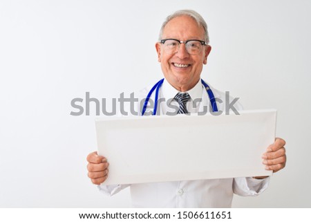 Senior grey-haired doctor man holding banner standing over isolated white background with a happy face standing and smiling with a confident smile showing teeth