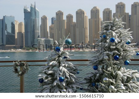 New Year holidays in Dubai. Christmas tree on the background of yachts and skyscrapers