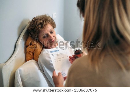 Female doctor giving a prescription to female senior patient