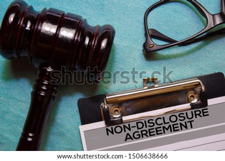 Non-Disclosure Agreement text on Document and gavel isolated on office desk. 
