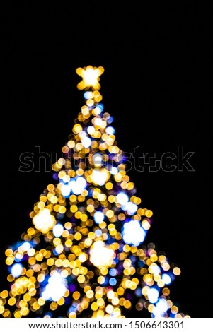 beautiful blurred lights illuminating the Christmas tree on a black background