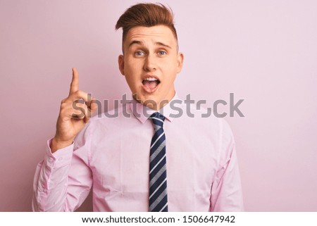 Young handsome businessman wearing shirt and tie standing over isolated pink background pointing finger up with successful idea. Exited and happy. Number one.