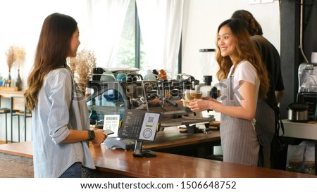 Young asian barista woman serving take out coffee cup to customer at counter in cooffee shop cafe background, asia small business owner, start up Royalty-Free Stock Photo #1506648752