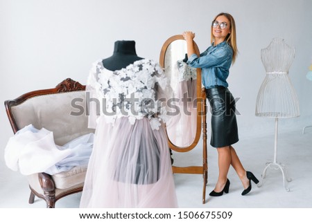 happy young fashion deisgner in her studio. concept of tailoring