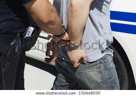 Officer Arresting Young Man Royalty-Free Stock Photo #150668030