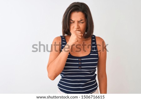 Young beautiful woman wearing blue striped t-shirt standing over isolated white background feeling unwell and coughing as symptom for cold or bronchitis. Healthcare concept.