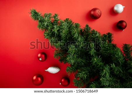 Christmas or new year winter composition.Pine tree and Red balls, decorative Christmas ornaments on red background. Flat lay, top view, copy space for text