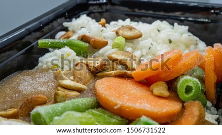 Frozen meal in a microwavable container. Includes chicken, cashews, rice, vegetables as carrots, green beans, peas and others. Royalty-Free Stock Photo #1506731522