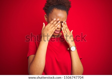 Young beautiful african american woman with afro hair over isolated red background rubbing eyes for fatigue and headache, sleepy and tired expression. Vision problem