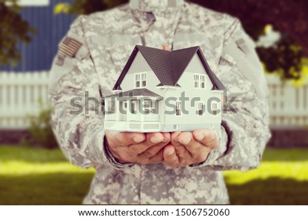 Miniature house in soldier hands