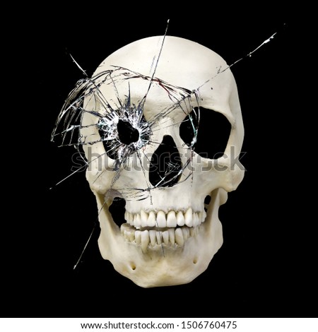 skull with a hole with cracks in the glass isolated on a black background