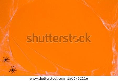 Orange background with spiders and web. Halloween holiday concept.