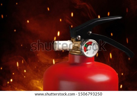 Red fire extinguisher and flames, close-up view