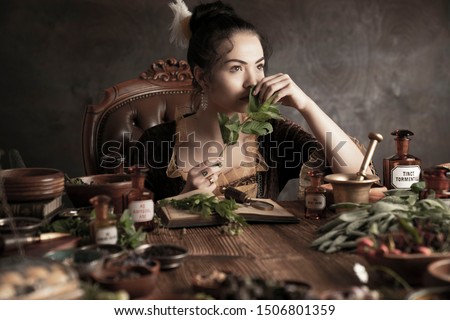 Natural medicine concept. Vintage female healer working with dry and fresh herbs. Royalty-Free Stock Photo #1506801359