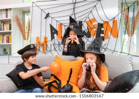 Children boy and  girls are blowing balloon to prepare Halloween party decoration