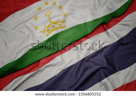 waving colorful flag of thailand and national flag of tajikistan. macro