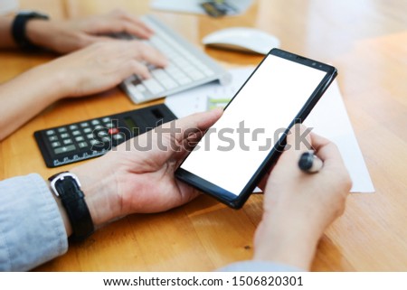 An image of a man holding a phone to access the application via the internet
